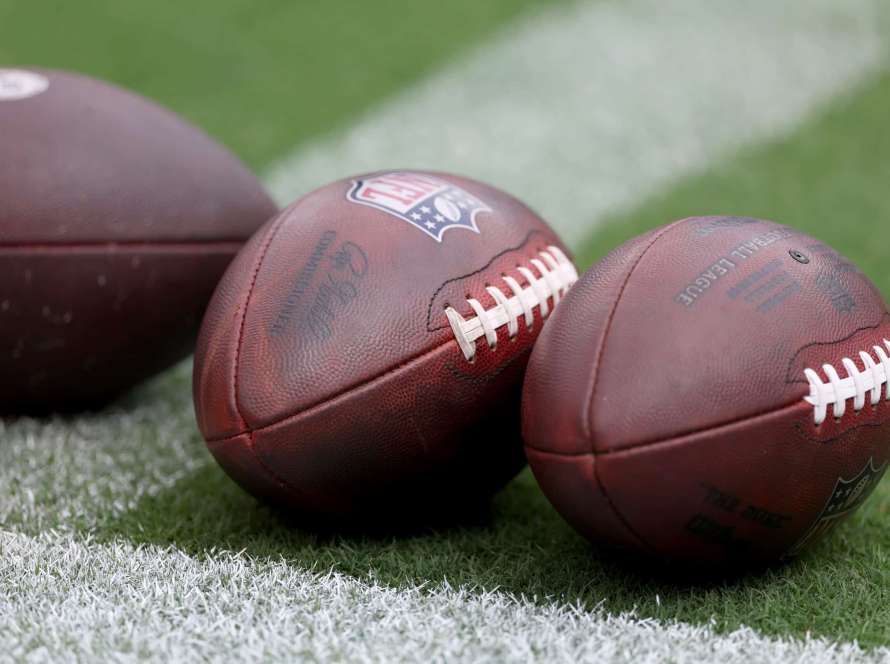 Footballs sit on the grass before the start of the Baltimore Ravens and Houston Texans game at M&T Bank Stadium on September 10, 2023 in Baltimore, Maryland.