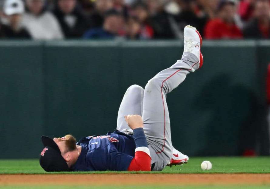 Trevor Story #10 of the Boston Red Sox reacts after being injured going after a ball hit by Mike Trout #27 of the Los Angeles Angels in the fourth inning during opening day of a Major League Baseball game at Angel Stadium of Anaheim on April 5, 2024 in Anaheim, California.