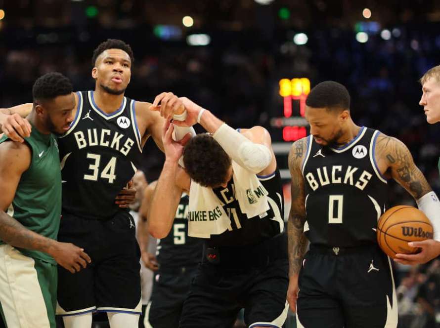 Giannis Antetokounmpo #34 of the Milwaukee Bucks is helped off the court by Thanasis Antetokounmpo #43 and Brook Lopez #11 after suffering an injury during the second half of a game against the Boston Celtics at Fiserv Forum on April 09, 2024 in Milwaukee, Wisconsin.