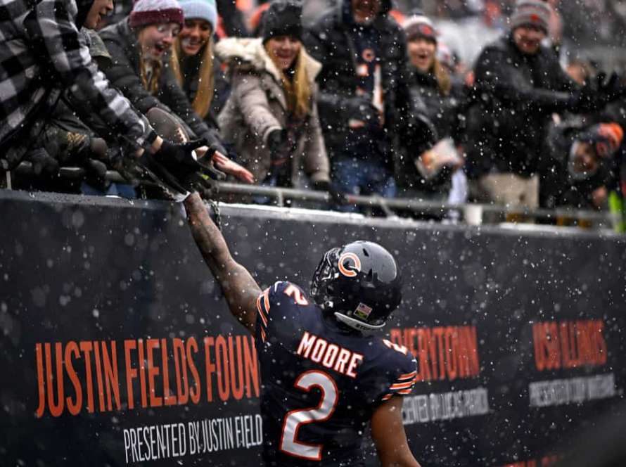 DJ Moore #2 of the Chicago Bears gives a fan a football after his receiving touchdown during the first quarter against the Atlanta Falcons at Soldier Field on December 31, 2023 in Chicago, Illinois.