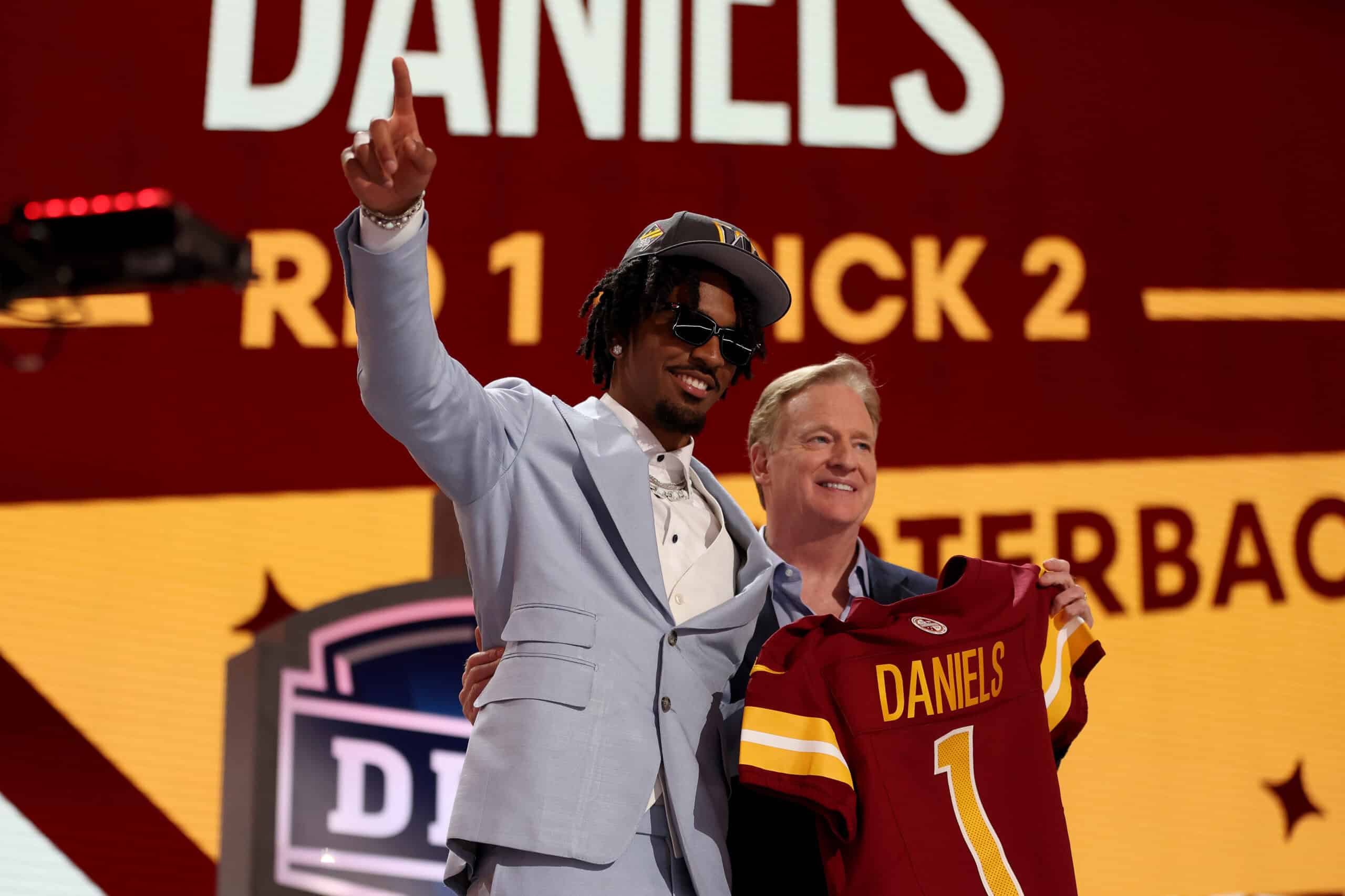 DETROIT, MICHIGAN - APRIL 25: Jayden Daniels poses with NFL Commissioner Roger Goodell after being selected second overall by the Washington Commanders during the first round of the 2024 NFL Draft at Campus Martius Park and Hart Plaza on April 25, 2024 in Detroit, Michigan.