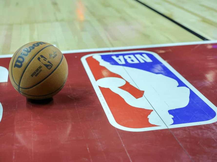 A basketball is placed on the court next to an NBA logo during a break in the first half of a 2023 NBA Summer League game between the Portland Trail Blazers and the Houston Rockets at the Thomas & Mack Center on July 07, 2023 in Las Vegas, Nevada.