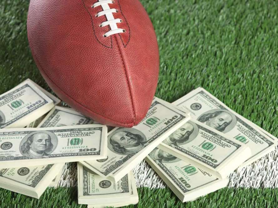 NFL football on field with a pile of money